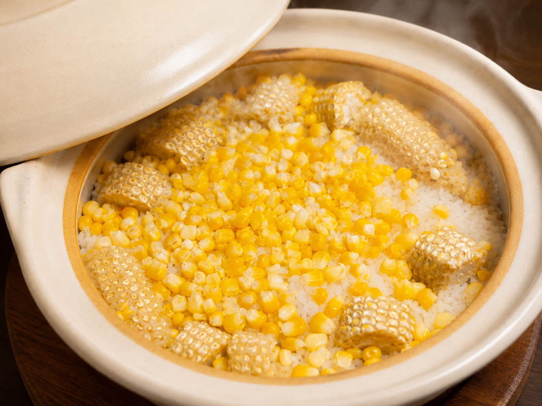 Tokyo corn rice just steamed in a donabe, lid lifted to show kernels over rice