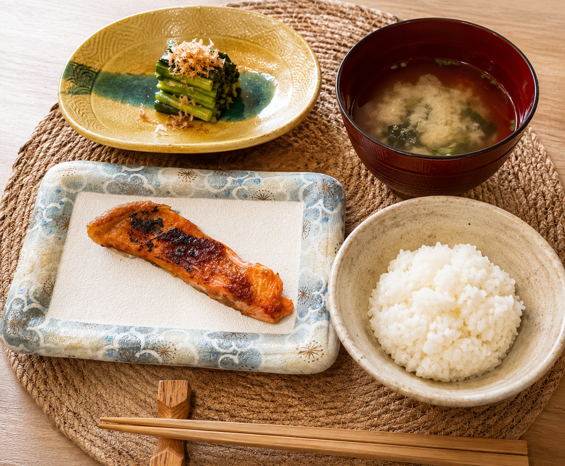 Japanese breakfast with rice, miso soup, grilled salmon, and seasonal greens