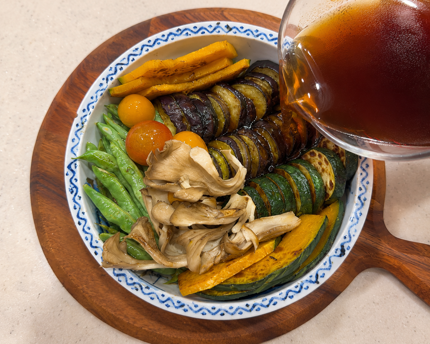 Hot dashi broth being poured over seared summer vegetables