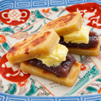 Toasted kankoro mochi sandwiches filled with sweet red bean paste and butter, on a patterned plate